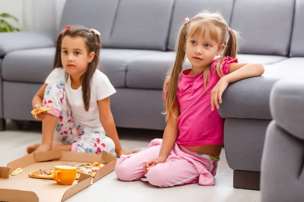 二人の小さな女の子食べる巨大ピザにホーム — ストック写真