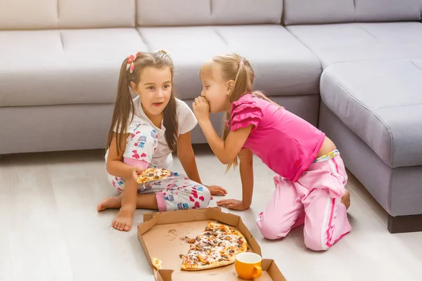 Deux petites filles mangent une énorme pizza à la maison — Photo