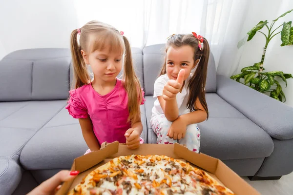 Duas meninas comendo pizza enorme em casa — Fotografia de Stock