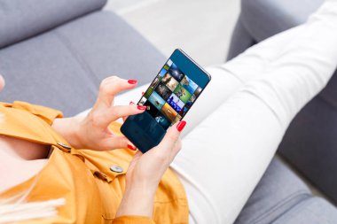 Ekranda kamera modu olan cep telefonu tutan kadın ellerinin yakın görüntüsü. Hipster bir kızın video izlerken çekilmiş görüntüsü.