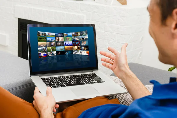 Hombre viendo canales de televisión por ordenador portátil en línea — Foto de Stock