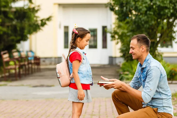 Der erste Schultag. Vater führt kleines Schulmädchen in die erste Klasse — Stockfoto