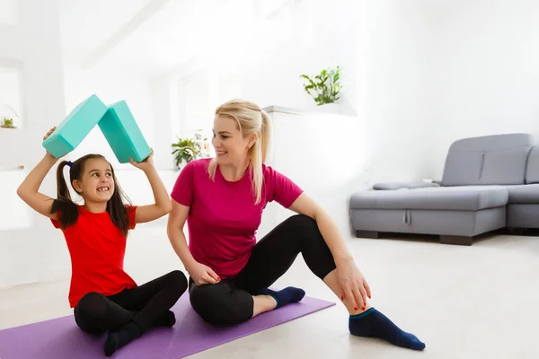 Family mother and child daughter are engaged in fitness, yoga, exercise at home — Stock Photo, Image