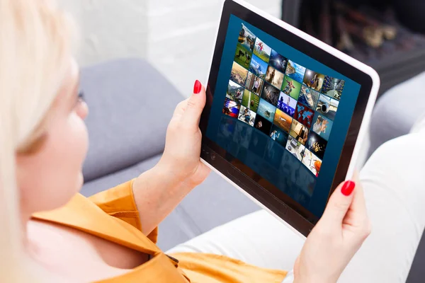 Young Woman Sitting Near The Sofa Watching Video On the tablet — Stock Photo, Image