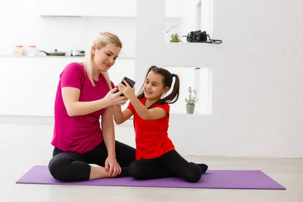 Family mother and child daughter are engaged in fitness, yoga, exercise at home — Stock Photo, Image