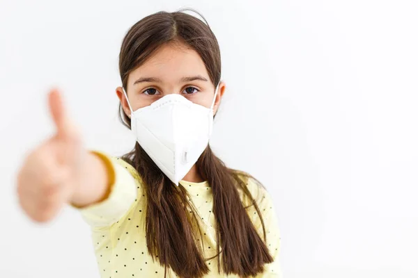 가벼운 배경에 일회용 마스크를 쓴 어린 소녀. 코로나 바이러스 유행병 예방 — 스톡 사진