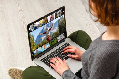 Kadın dizüstü bilgisayarla video izliyor. Video izleme kavramı, COVID-19 koronavirüs salgını sırasında çalışma
