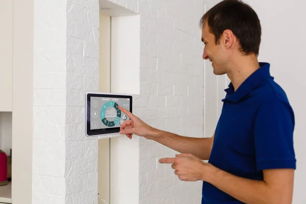 Бизнесмен держит планшетный компьютер с системой умный дом — стоковое фото