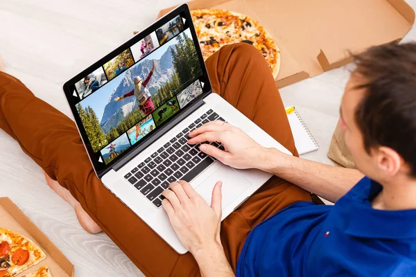 Hombre viendo canales de televisión por ordenador portátil en línea — Foto de Stock