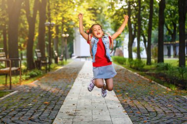 Sabahları küçük bir kız sıcak güneşin altında sırt çantasıyla okula gidiyor. Eğitim kavramı.