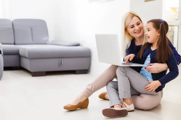 Hermosa mujer ayudando a su hija haciendo su tarea en una cocina — Foto de Stock