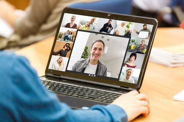 Vista trasera del joven usando auriculares y laptop y teniendo videoconferencia en casa — Foto de Stock