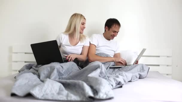 A young boy using a laptop computer sitting on top of a bed — Stock Video