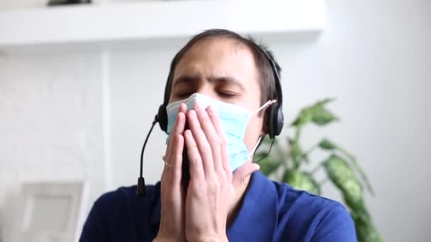 Um homem usando uma camisa azul e sorrindo para a máscara da câmera coronavírus — Vídeo de Stock