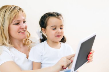 Anne ve kızı tablet kullanıyor.