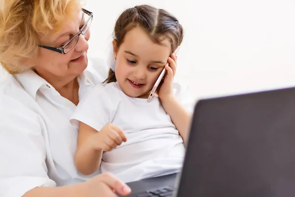 Menina e avó aprendendo on-line no laptop — Fotografia de Stock