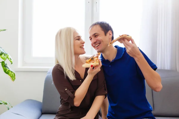 Νεαρό ζευγάρι τρώει πίτσα στο σπίτι — Φωτογραφία Αρχείου
