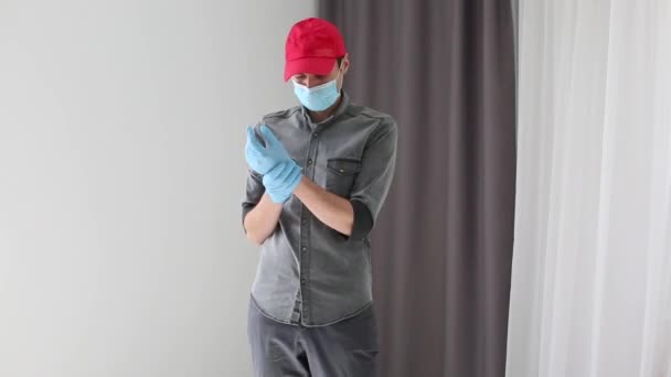 Mensajero, repartidor con máscara protectora y guantes médicos. Quédate en casa. . — Vídeos de Stock