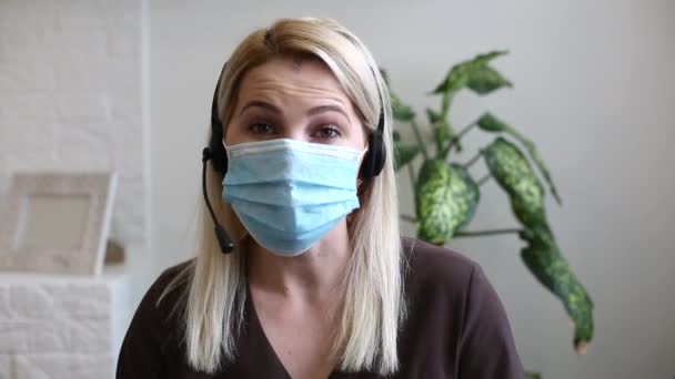 Een vrouw draagt een masker coronavirus online — Stockvideo