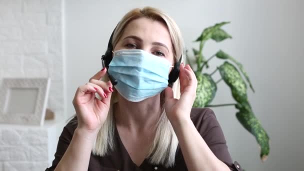 Eine Frau spricht auf einem Handy online Maske Coronavirus — Stockvideo