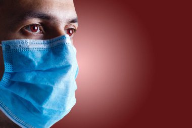 Adam yüz koruyucu maske takıyor.