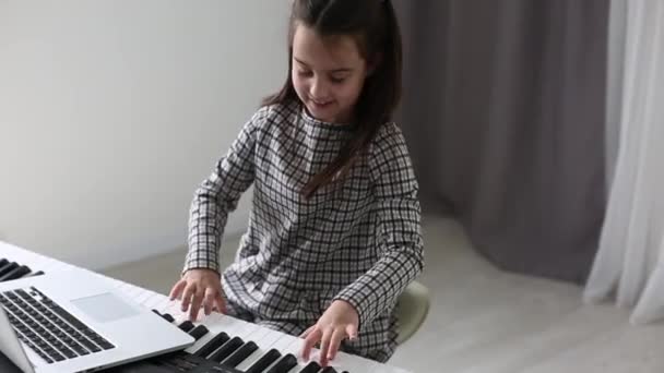 Σκηνή των μαθημάτων πιάνου σε απευθείας σύνδεση εκπαίδευση ή E-class μάθηση, ενώ Coronavirus εξαπλωθεί ή covid-19 κατάσταση κρίσης, κοριτσάκι που σπουδάζει από το σπίτι. — Αρχείο Βίντεο