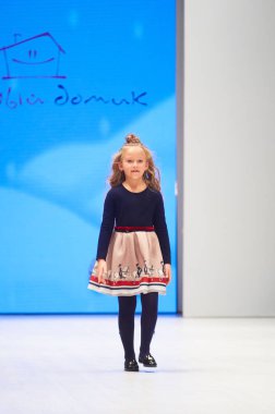 MINSK-OCTOBER 29: An unidentified girl wears Modny Domik colection at the international exhibition of the fashion industry, Kid's fashion day during Belarus Fashion Week on October 29, 2017 in Minsk,  clipart