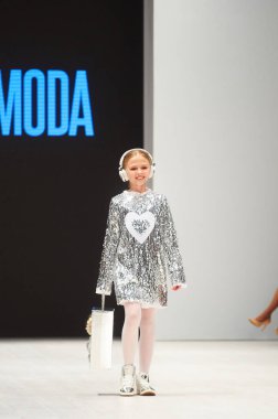 MINSK-OCTOBER 29: An unidentified girl wears ARTMODA collection at the international exhibition of the fashion industry, Kid's fashion day during Belarus Fashion Week on October 29, 2017 in Minsk, Bel clipart