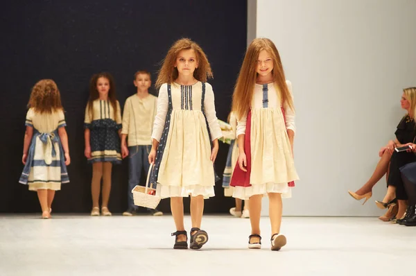 Minsk-oktober 29: En oidentifierad flicka bär Kutsepova samling vid den internationella utställningen av modebranschen, Kids mode dag under Vitryssland Fashion Week 29 oktober 2017 i Minsk, B Stockfoto