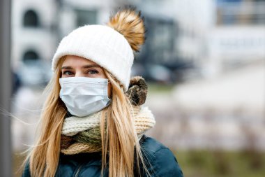 Kadın alerji, virüs ve hava kirliliğine karşı koruyucu bir maske takıyor. İklim değişikliğini kabul et.