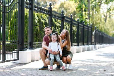 Kızı olan genç bir aile parkta eğleniyor..