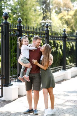 Kızı olan genç bir aile parkta eğleniyor..