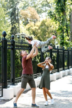 Kızı olan genç bir aile parkta eğleniyor..