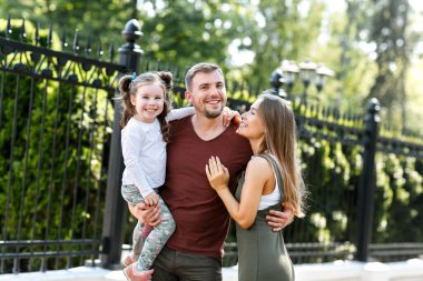 Kızları olan genç bir aile parkta eğleniyor..