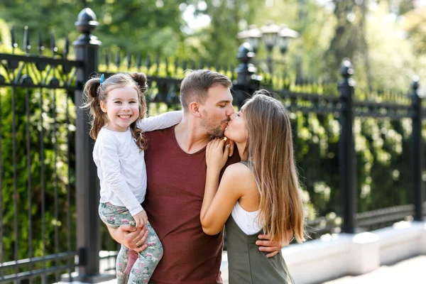 Kızları olan genç bir aile parkta eğleniyor..