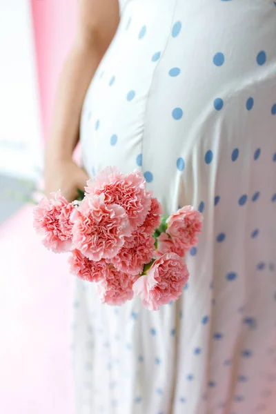 Zbliżenie Kobiety Ciąży Trzymając Różowy Kwiat Brzuchu Izolacja Różowym Tle — Zdjęcie stockowe