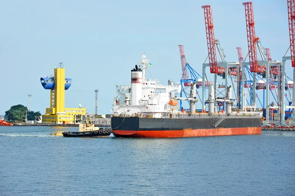 Tugboat assisting bulk cargo ship