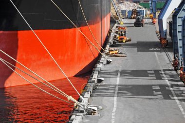 Bulk cargo ship under port crane clipart