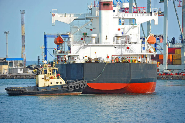 Tugboat assisting bulk cargo ship