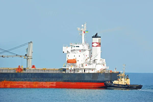 Tugboat assisting bulk cargo ship — Stock Photo, Image