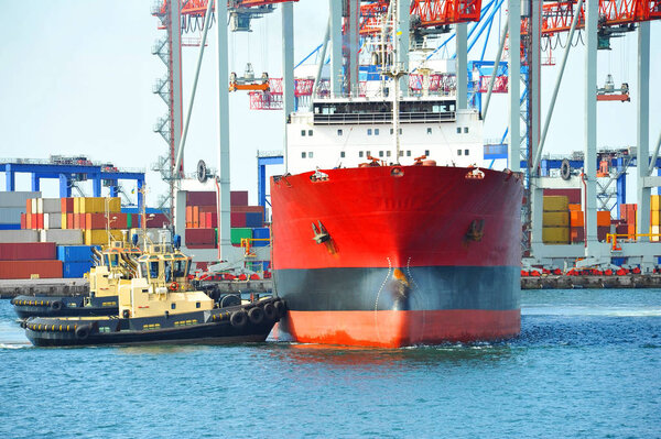 Tugboat assisting bulk cargo ship