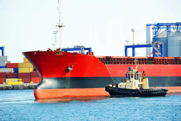 Tugboat assisting bulk cargo ship