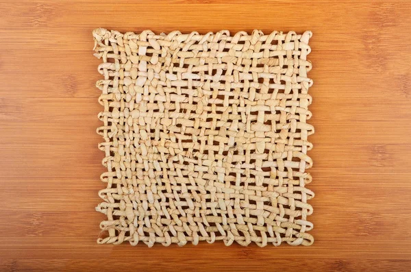 Плетеная салфетка на деревянном фоне — стоковое фото