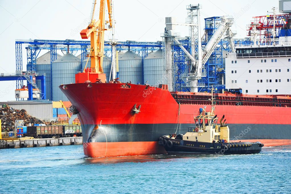 Tugboat assisting bulk cargo ship