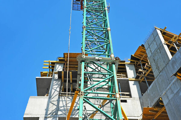 Crane and building under construction against blue sky