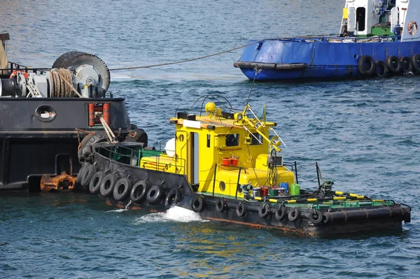 Tugboat assisting floating cargo crane Royalty Free Stock Images