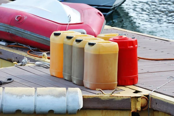 Caixote com combustível e barco — Fotografia de Stock
