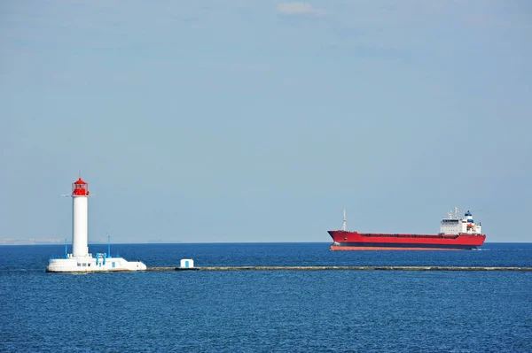 Loď přepravující hromadné náklady u majáku — Stock fotografie