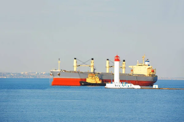 Канонерський човен, що допомагає вантажному кораблю — стокове фото