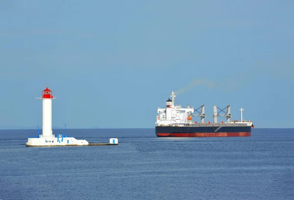 Bulk carrier near lighthouse — Stock Photo, Image